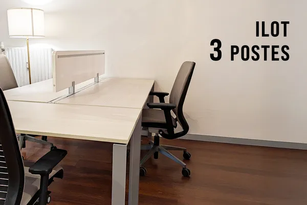 Espace de coworking avec 3 postes de travail équipés, bureau en bois et lumière naturelle